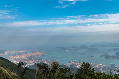 Aerial view of townscape by sea against sky