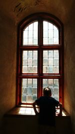 Rear view of woman sitting in window