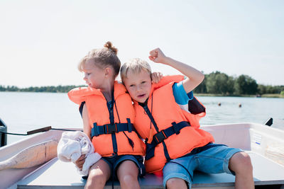 Siblings hugging on a boat trip in summer in sweden