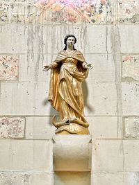Low angle view of statue against wall