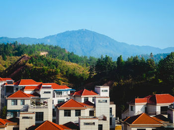 Houses and mountains against clear sky