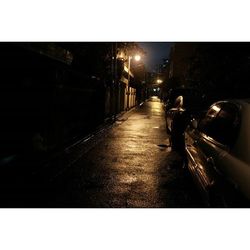 People walking on illuminated street at night