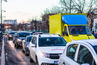 Cars parked on road against sky in city