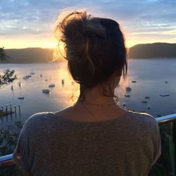 Rear view of woman at beach during sunset