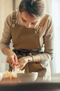 Side view of girl playing with cookies at home