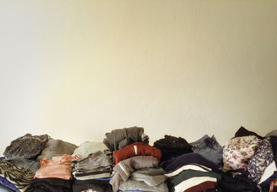 Stack of folded clothes against wall