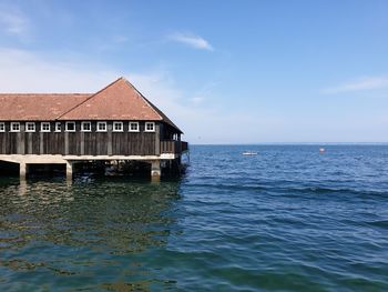 House by sea against blue sky