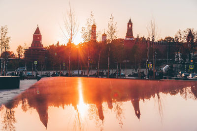 Reflection of buildings in city at sunset