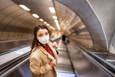 High angle view of woman wearing mask on escalator