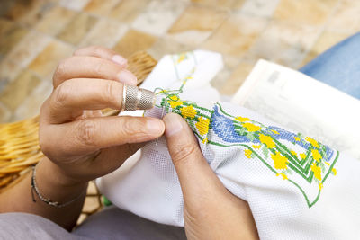 Midsection of woman embroidering on fabric