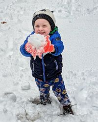 Boy playing with snow during winter