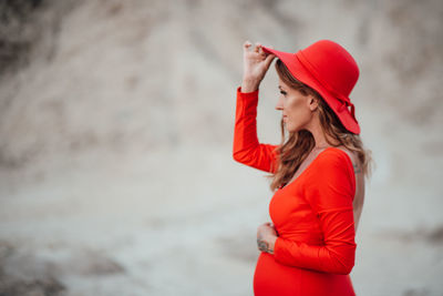 Young woman looking away while standing outdoors