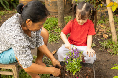 Girl and woman standing by plants