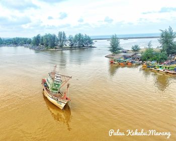 Boats moored on river against sky