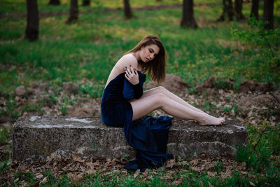 Portrait of a young woman sitting on land