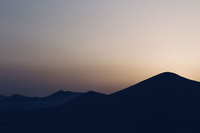 Scenic view of silhouette mountains against sky at sunset