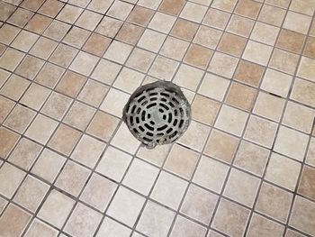High angle view of manhole on tiled floor