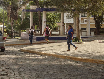 People running on walkway in city