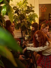 Portrait of smiling friends standing against plants