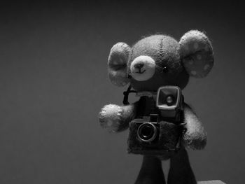 Close-up of teddy bear with cameras against gray background