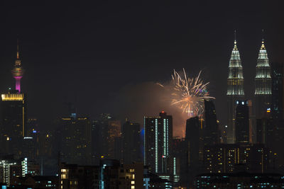 Firework display over city lit up at night