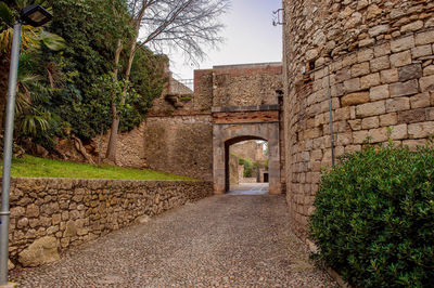 Footpath by old building against sky