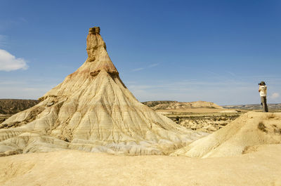 Man taking photos in the natural park of bardenas reales. biosphere reserve by unesco. travel