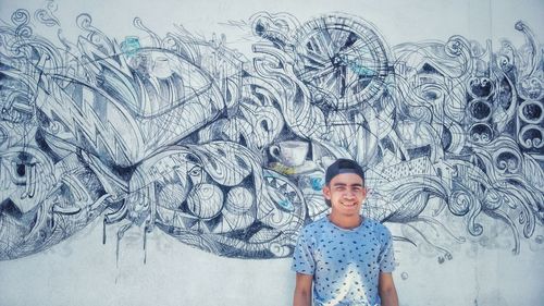 Portrait of smiling boy standing against wall