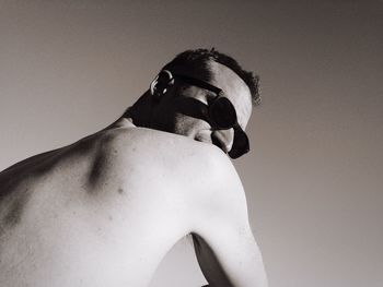 Low angle view of shirtless man against clear sky