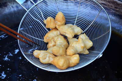 High angle view of food in strainer over wok