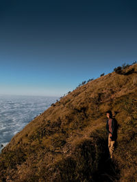 Man standing by sea against clear sky