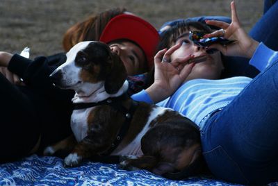 Siblings lying with beagle outdoors