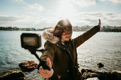 Full length of woman standing in sea against sky