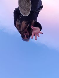 Low angle view of woman against blue sky