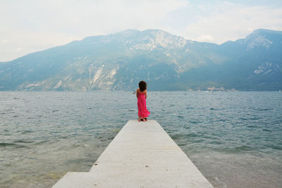 Rear view of woman on mountain against sky