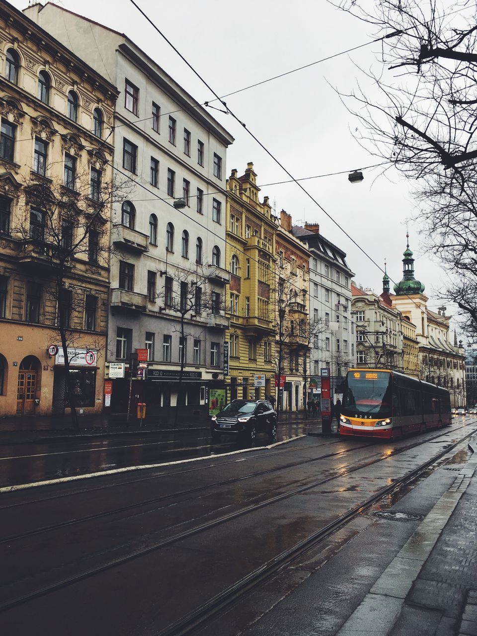 VIEW OF RAILROAD TRACKS BY BUILDINGS IN CITY AGAINST SKY