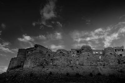 Low angle view of old building against cloudy sky