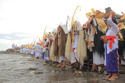 Group of people in traditional temple against sky