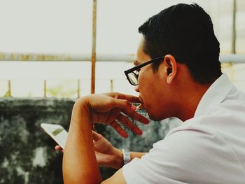 Side view portrait of young man sitting outdoors