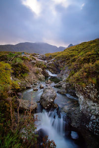 Scenic view of river amidst mountains against sky