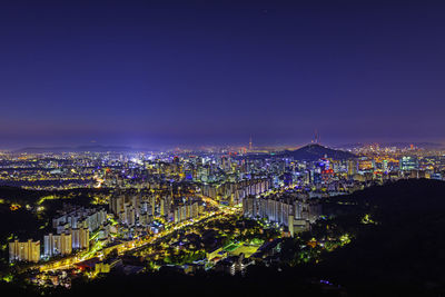 High angle view of city lit up at night