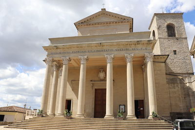 Low angle view of building against cloudy sky - basilica of san marino