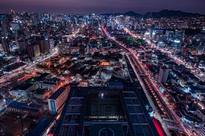 High angle view of city lit up at night