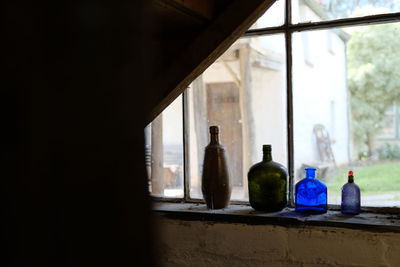 Close-up of bottles on window sill
