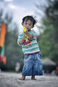 Full length portrait of boy playing with squirt gun