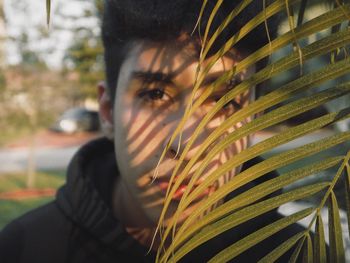 Close-up portrait of young man holding plants