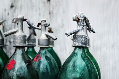 Close-up of old bottles against wall