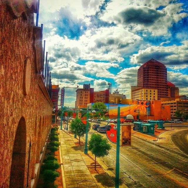 building exterior, architecture, built structure, sky, cloud - sky, city, the way forward, cloud, street, building, residential structure, residential building, incidental people, tree, diminishing perspective, cloudy, footpath, day, outdoors, city life