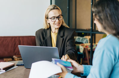 Portrait of young woman using laptop at office
