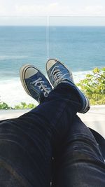 Low section of man relaxing by sea